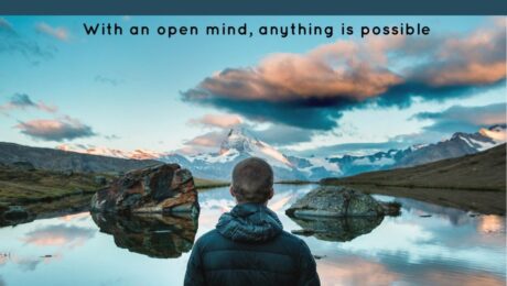 Person standing by tranquil lake at sunset.